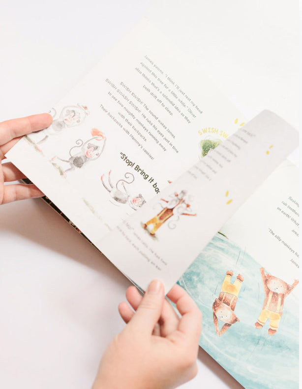 hand turning pages in the story book for toddlers Oliver and James